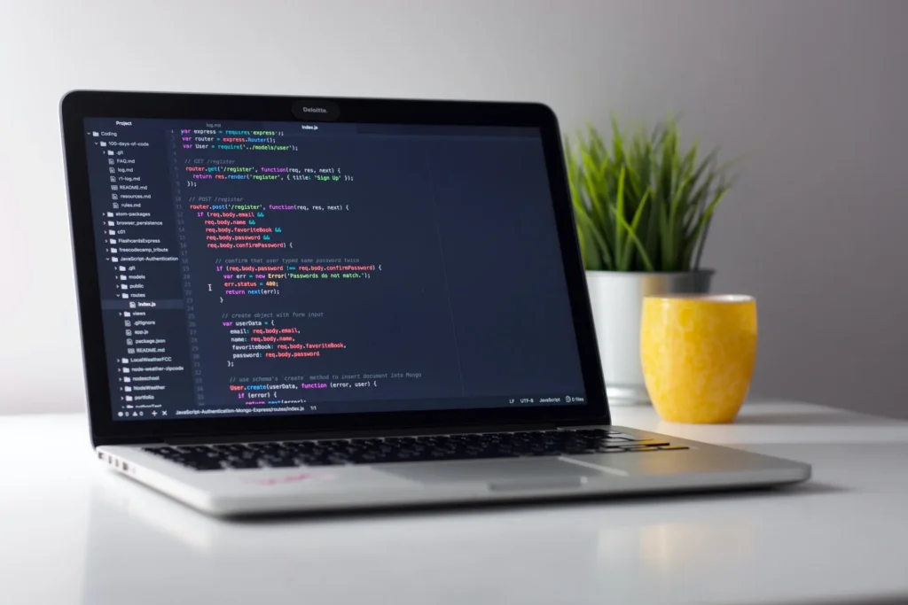 Laptop mit Code auf dem Schreibtisch