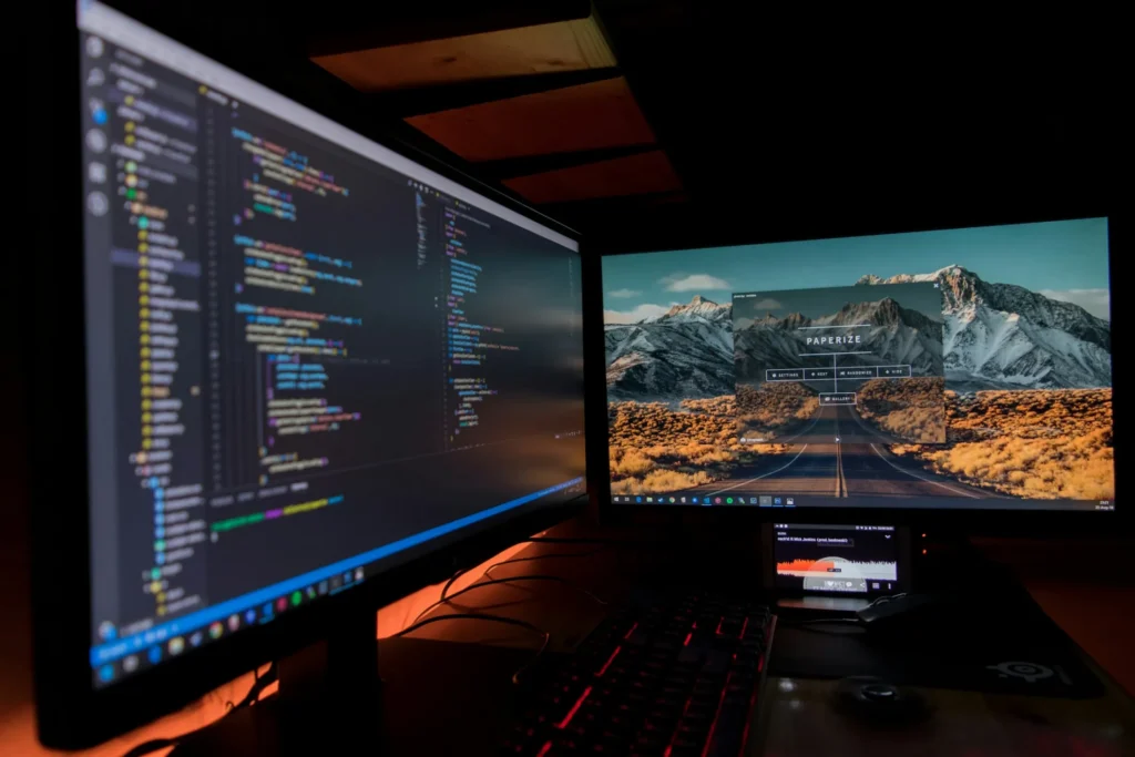 Zwei Monitore mit Programmcode und einer fertigen Website: Webdesign-Referenzen und Projekte aus Ulm