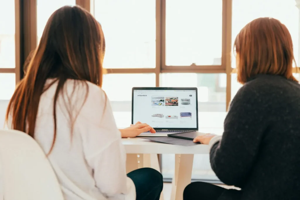 Zwei Frauen im Beratungsgespräch am Laptop: Häufige Fragen zu Kosten und Beratung für Ihre Website in Ulm